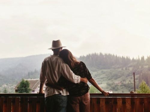Couple watching the sunset from their new house